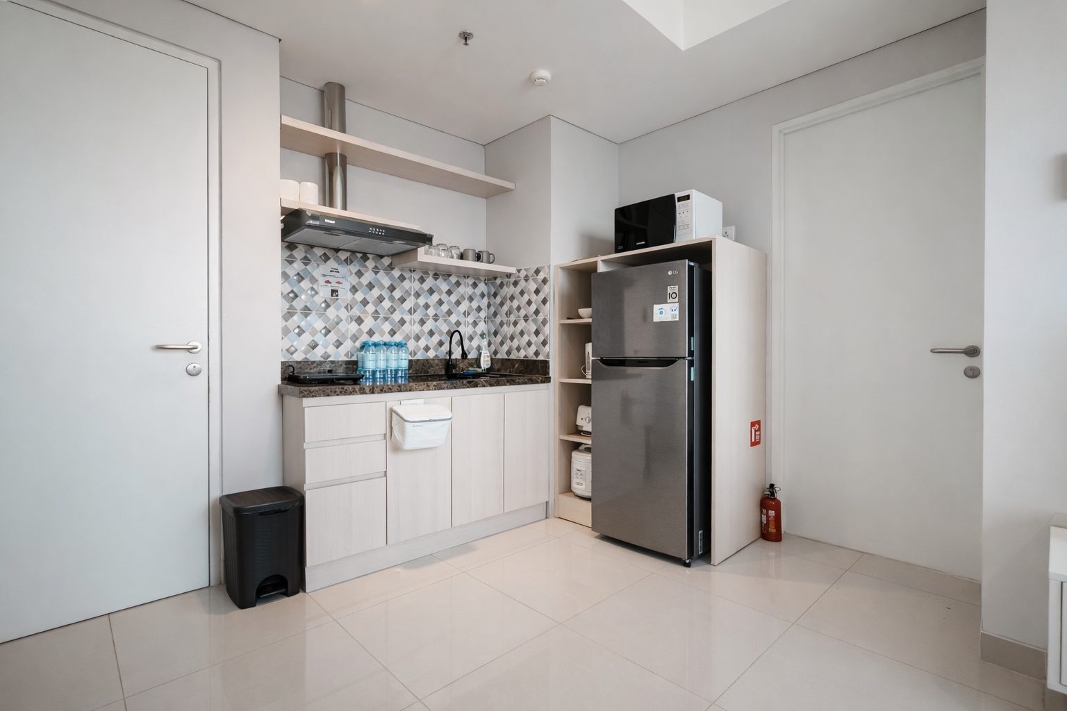 Kitchen with refrigerator and cooking area in a Kalani Tower Batam apartment